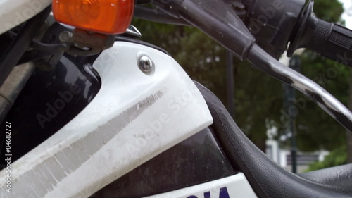 Close up tilt up shot of a police motorbike marked policia in spanish and the flashing red and blue lights that are attached to the motorcycle.