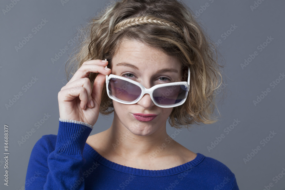 adorable 20s girl looking over her girly sunglasses