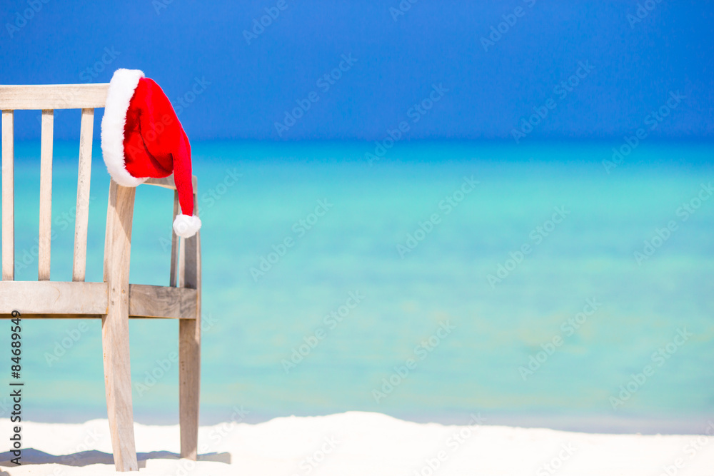 Red santa hat on beach chair at tropical vacation Red santa hat on beach chair at tropical vacation