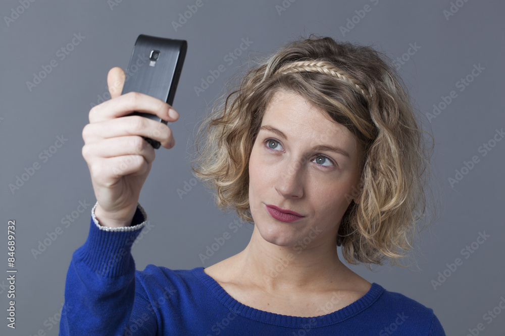 focused young blonde girl taking her selfie with her telephone focused young blonde girl taking her selfie with her telephone