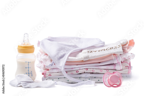 Folded clothes for babies with a bottle of milk and pacifier photo