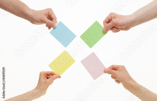 Human hands holding colorful paper cards