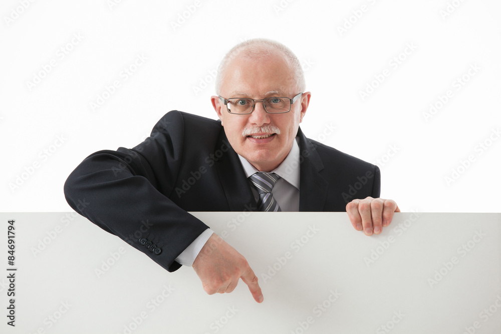 Smiling mature businessman showing something on white board. Smiling mature businessman showing something on white board.