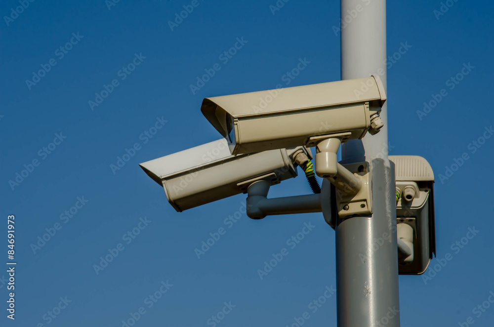 Three cctv camera on metal light pole, blue sky background Three cctv camera on metal light pole, blue sky background