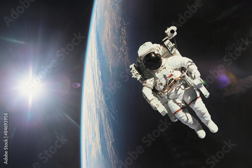 Astronaut in outer space with planet earth as backdrop. Elements #84693956