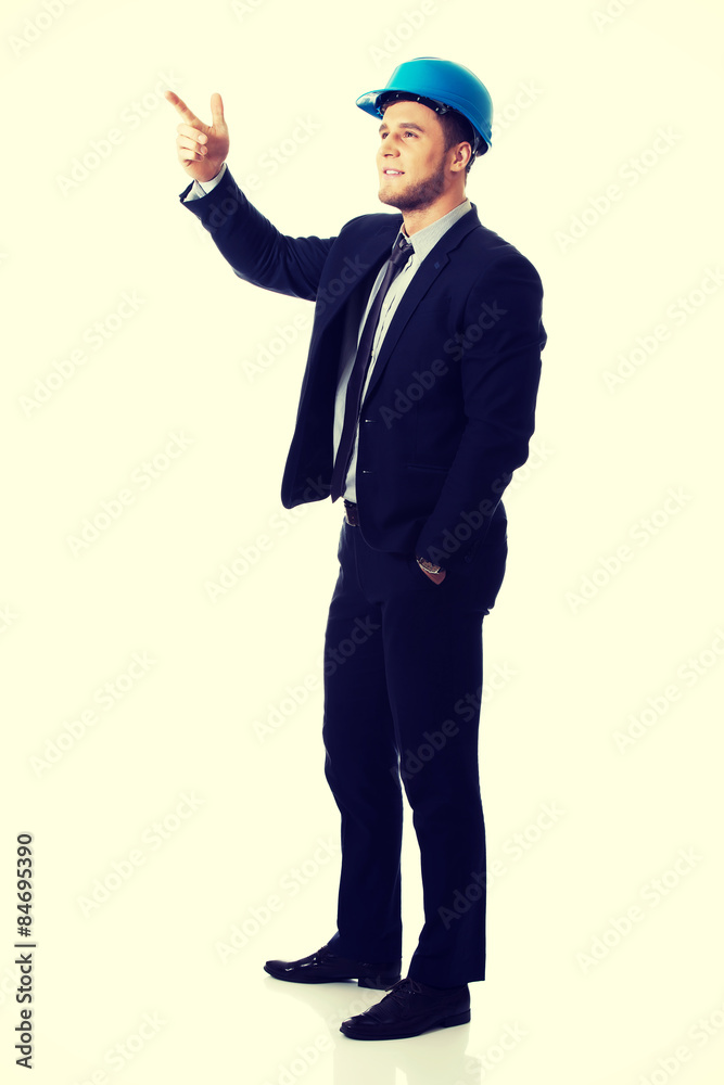 Happy businessman in helmet points his finger up. Happy businessman in helmet points his finger up.