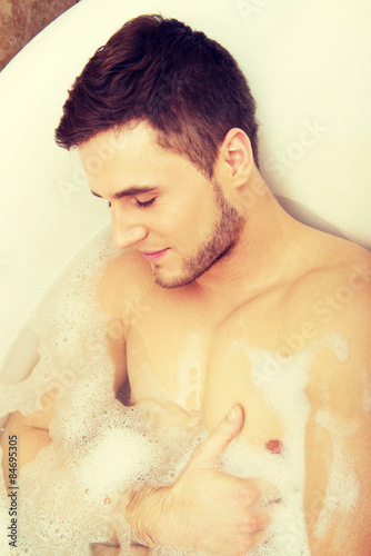 Handsome man taking a bath.
