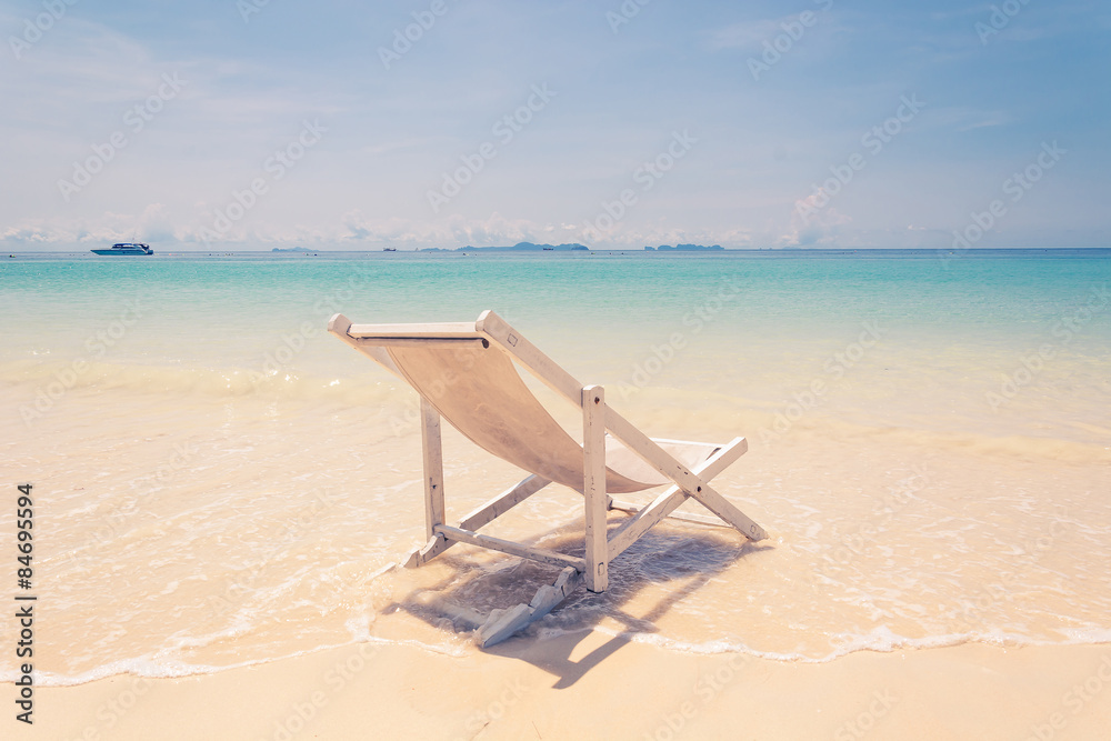 beach chair on beach with blue sky - soft focus with film filter