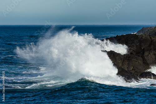 Wave crashing ashore on rocky beach