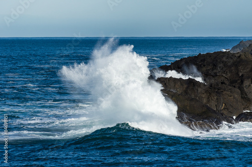 Wave crashing ashore on rocky beach