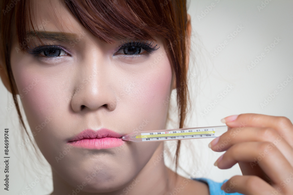 Sick woman holding thermometer
