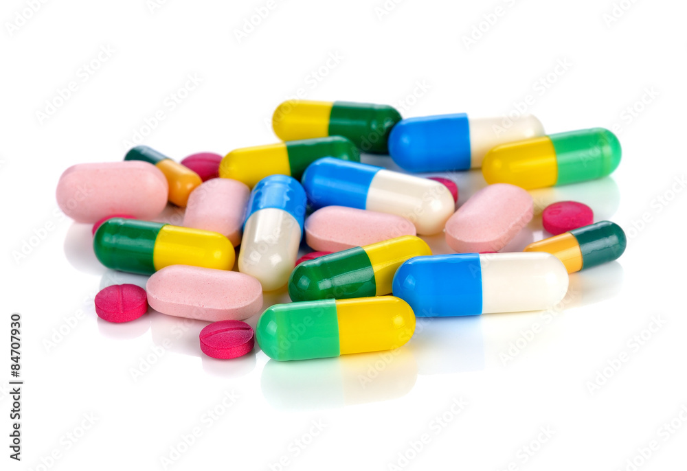 Colored pills, tablets and capsules on a white background Colored pills, tablets and capsules on a white background