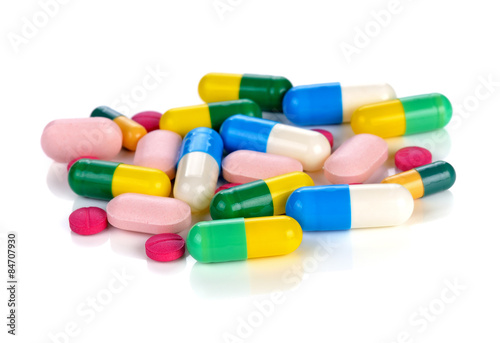 Colored pills, tablets and capsules on a white background