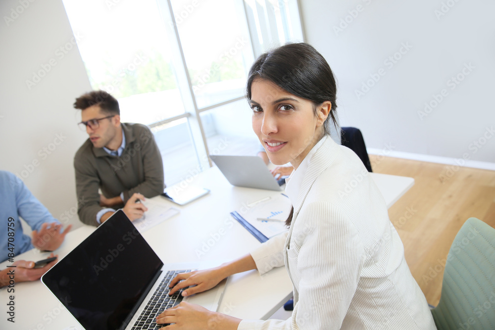 Obraz premium Businesswoman working on laptop, shared workspace