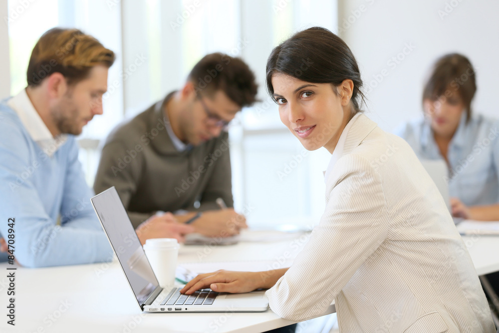 Businesswoman working on laptop, shared workspace Businesswoman working on laptop, shared workspace