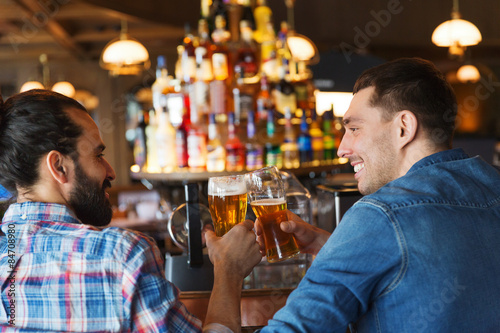 Canvas Print happy male friends drinking beer at bar or pub