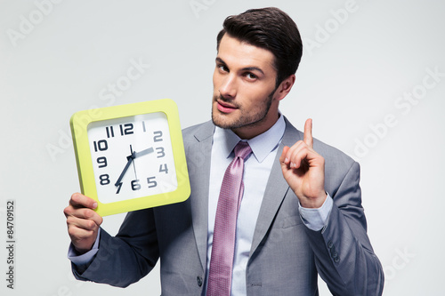 Tablou pe pânză Businessman holding clock