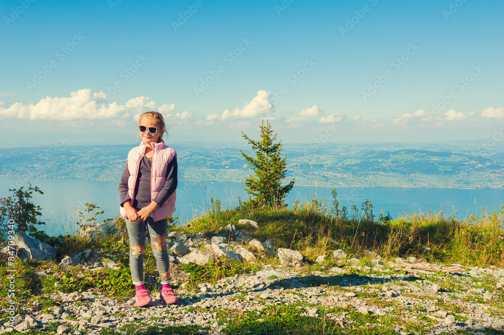 Cute little girl resting on the top of the mountain 