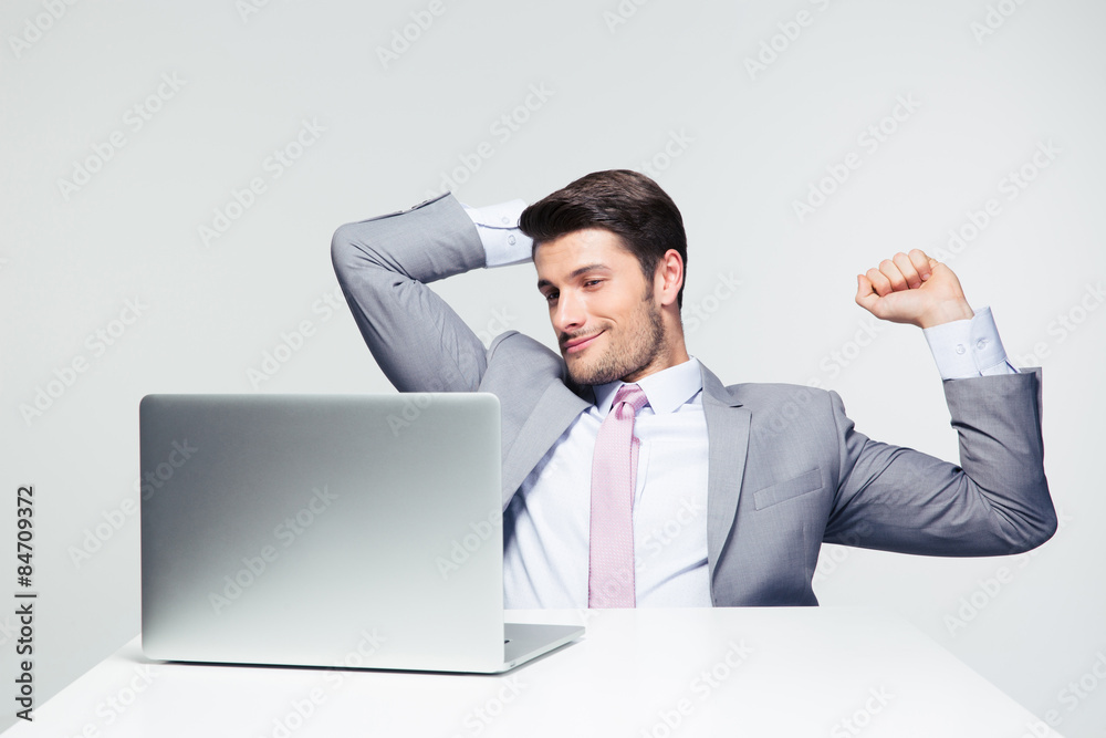 Happy businessman looking at laptop