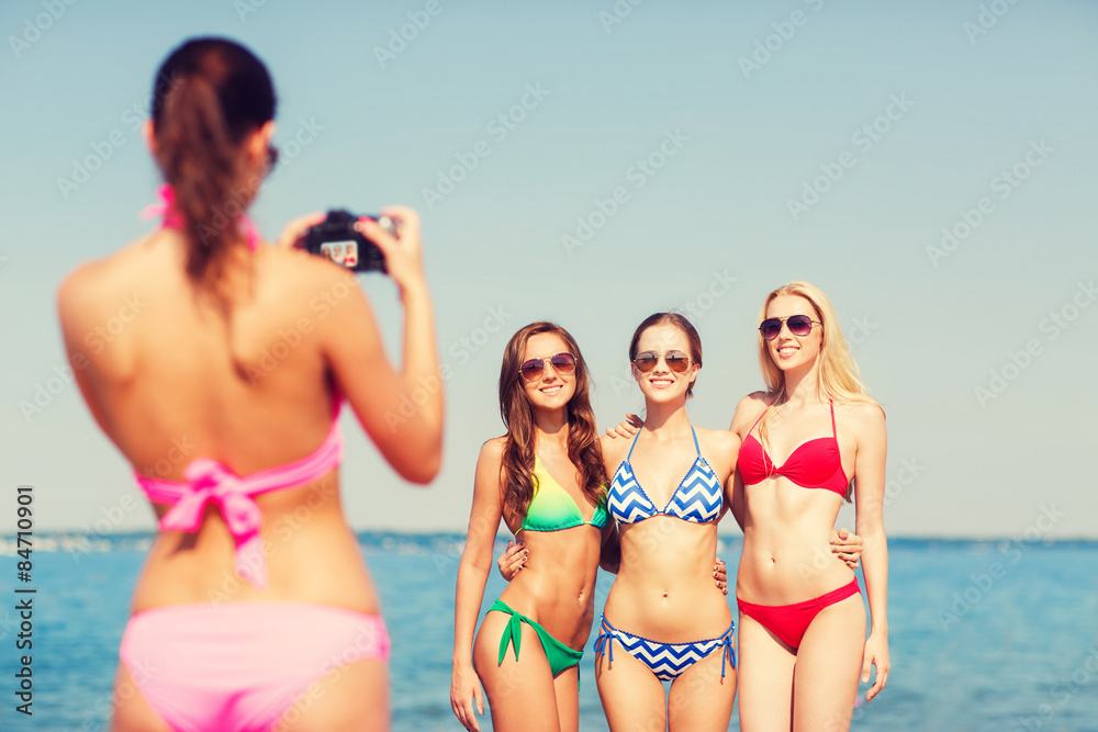 group of smiling women photographing on beach group of smiling women photographing on beach