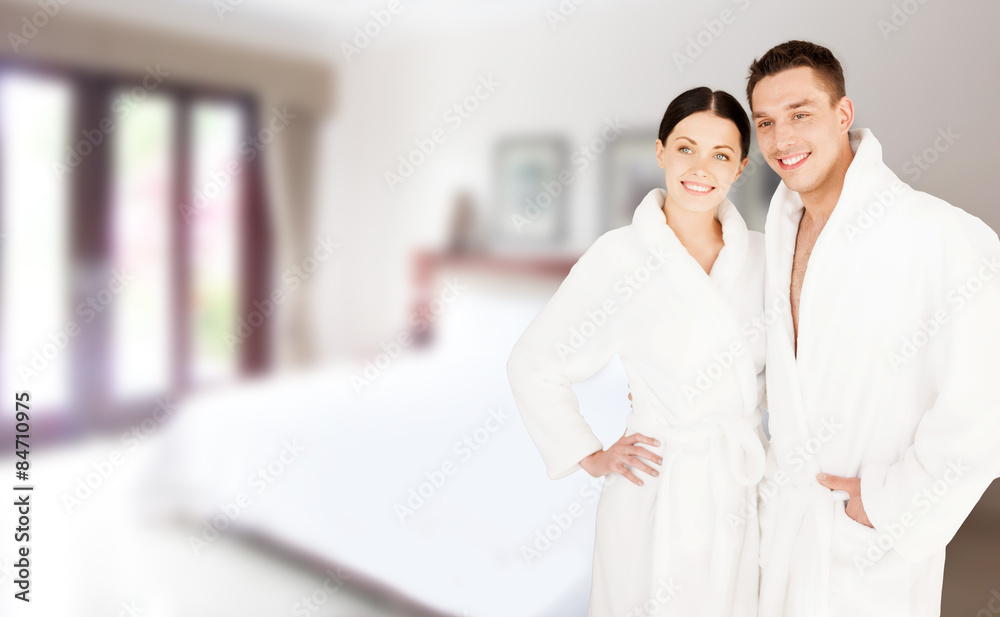 Obraz premium happy couple in bathrobes over spa hotel room