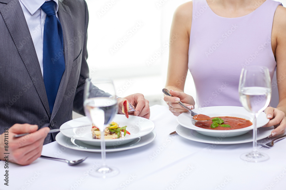 close up of couple eating appetizers at restaurant