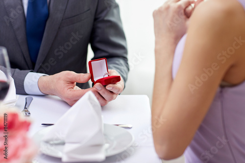excited young woman and boyfriend giving her ring