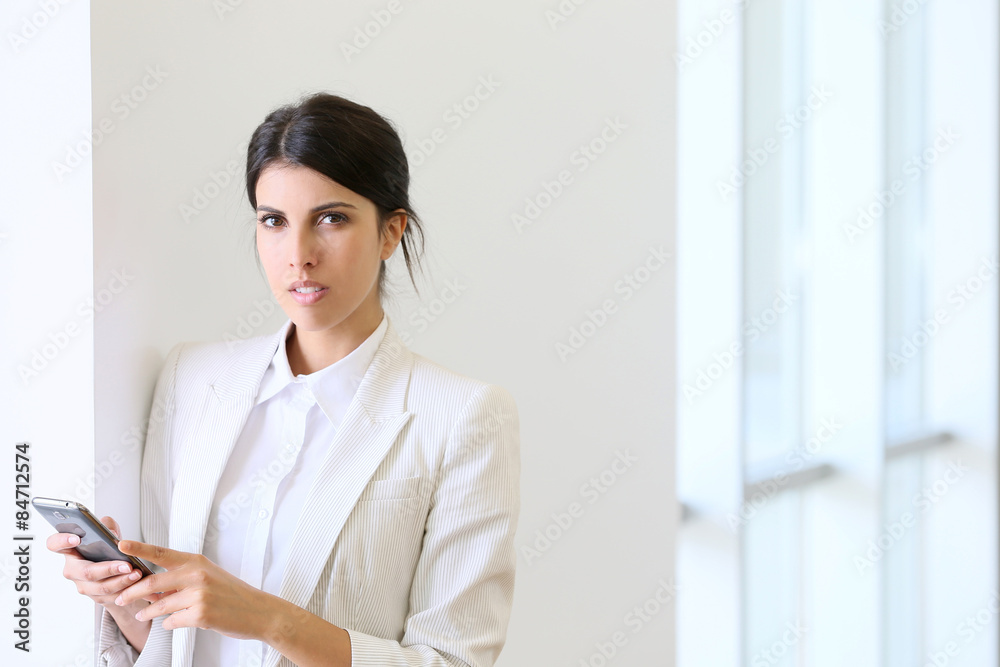Executive woman using smartphone in hallway Executive woman using smartphone in hallway