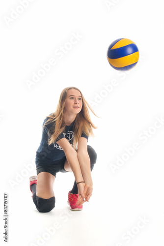 Mädchen schlägt unter einen Volleyball 
