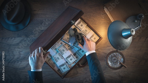 Vintage gangster with gun and dollars photo