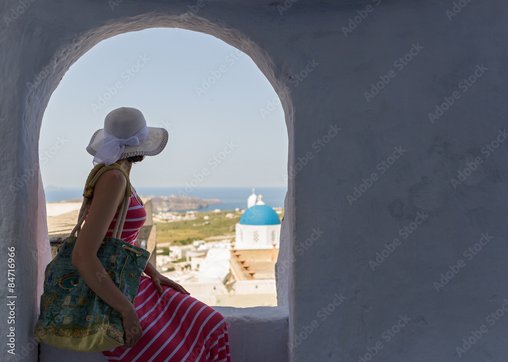 Woman sits on a wall, island Santorini