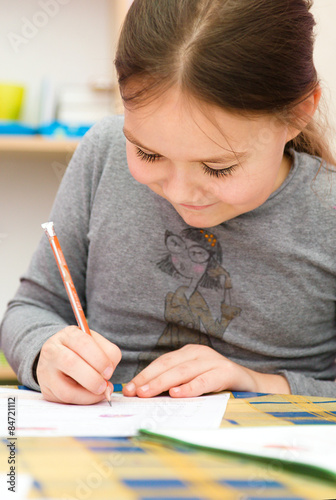 Cute girl is drawing using pencils