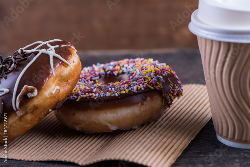 fresh artisan donuts and take away coffee, wooden background