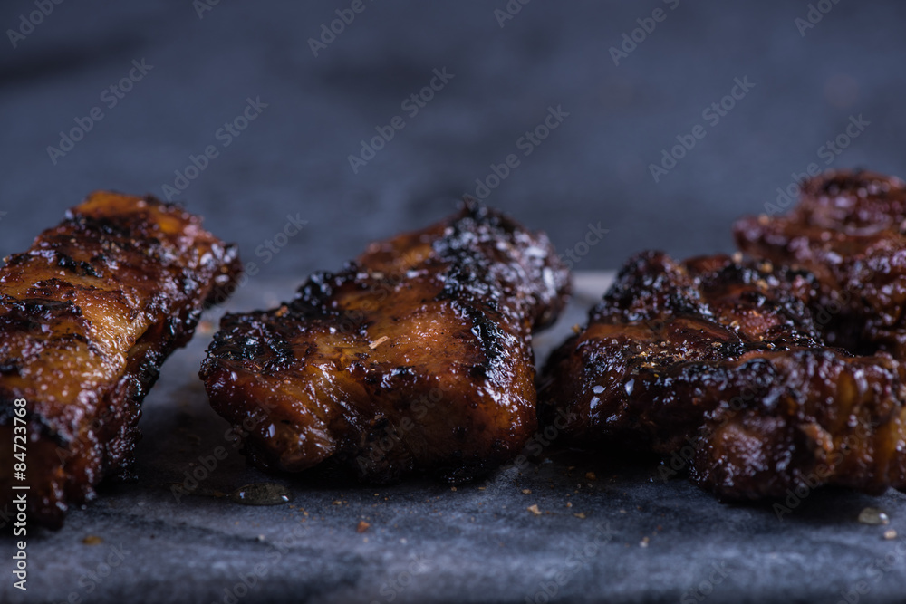 Grilled pork belly slices on marble board and slate background