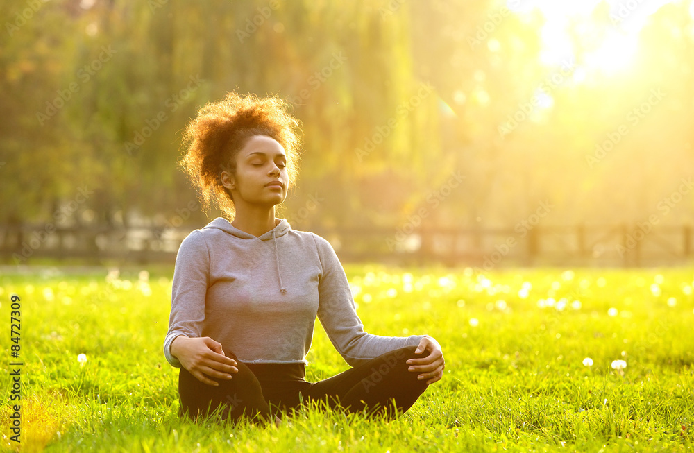 African american woman meditating in nature - obrazy, fototapety, plakaty 