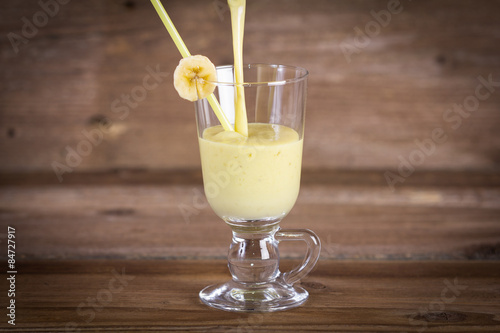 Milk shake from banana on wooden background