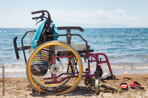 wheelchair on the beach against blue sea in summer