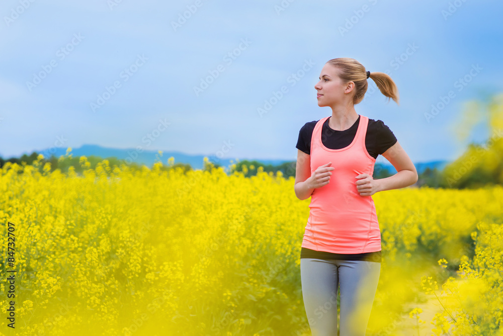 Young runner outside in spring canola field Young runner outside in spring canola field
