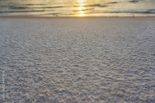 Abstract photo of defocused sand on beach with sunset reflect