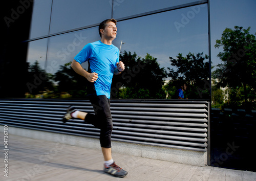 young attractive man running and training on urban street background