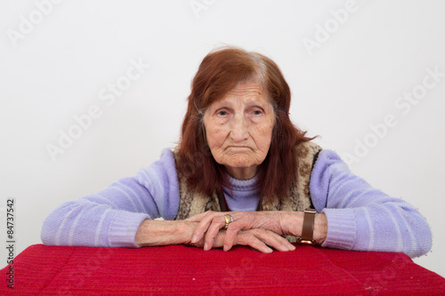 Portrait of an elderly woman with sad face expression.