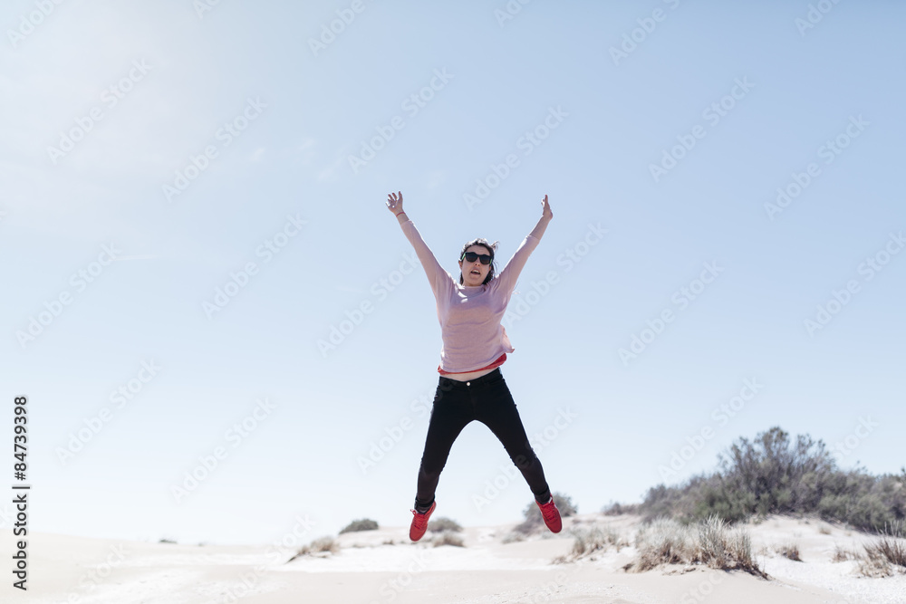 Happy woman jumping on big beach. Beautiful day of spring Happy woman jumping on big beach. Beautiful day of spring