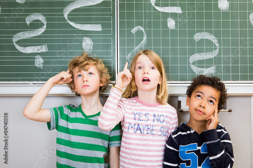 Kinder nachdenklich an der Tafel Schule 