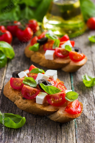 bruschetta with tomato, feta cheese, olives and basil