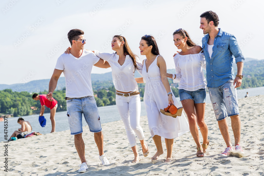 Obraz premium Group of young people holding hands on beach