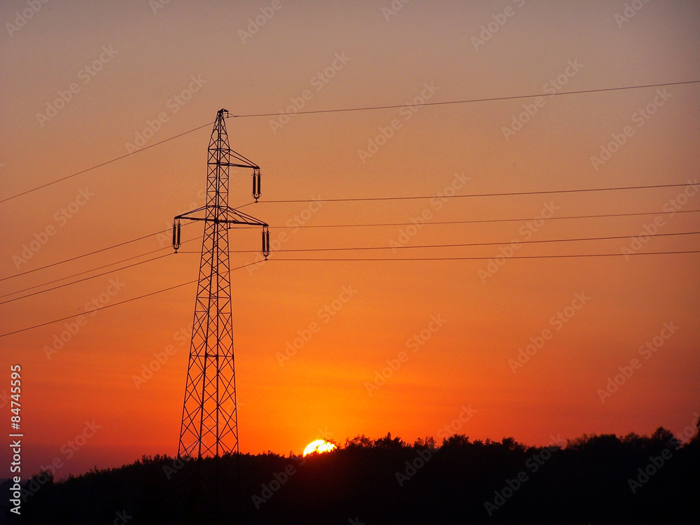 Transmission tower against sunset sky