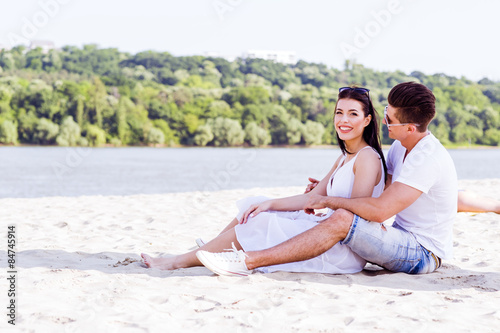 Romantic young couple sitting at a beach