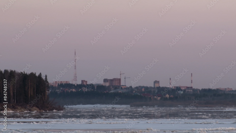 River on the background of the city/In spring, the river quickly floating ice. Beyond the river city, the city is building, moving cranes. The evening gives way to night River on the background of the city/In spring, the river quickly floating ice. Beyond the river city, the city is building, moving cranes. The evening gives way to night