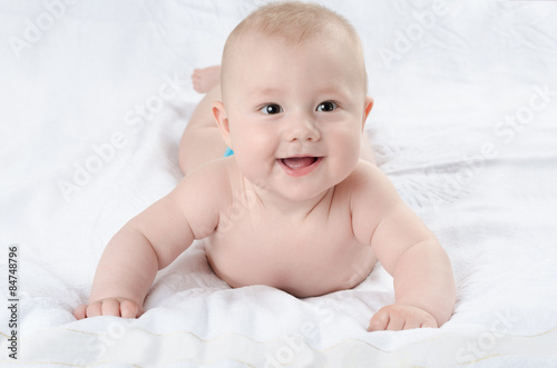 happy baby lying on a white rug