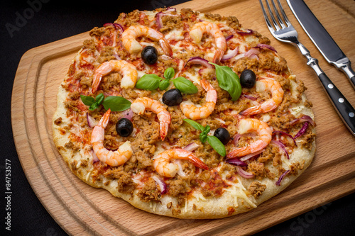 Tuna pizza with shrimp and olive, cutlery